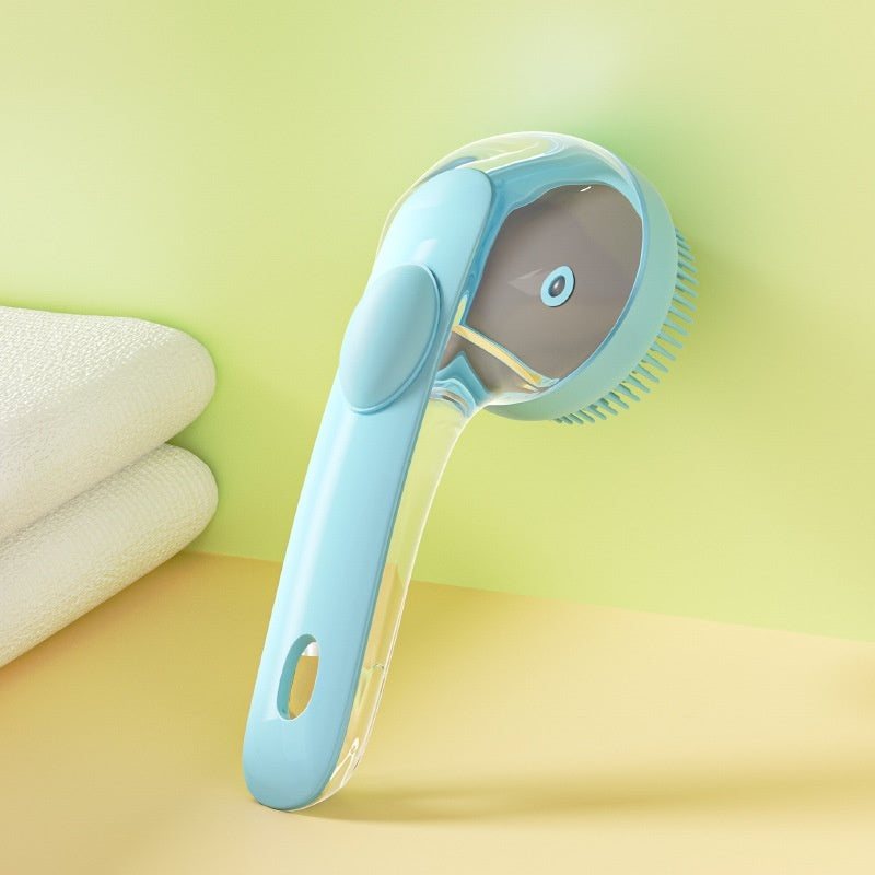 Blue silicone dog and cat bath brush with clear shampoo dispenser handle, beside folded towels