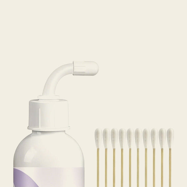 Ear wash bottle top with its bendable nozzle, beside the cotton swabs that come with it
